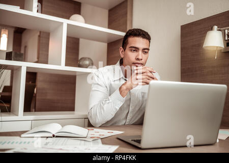 Junge Unternehmer Lesen wichtiger Geschäftsbrief auf seinem Laptop Stockfoto