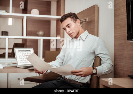 Mann mit gestreiften Hemd Lesen wichtiger Dokumente Stockfoto