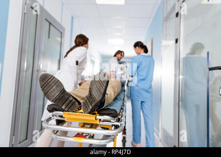 Ärzte in Uniform Transport von Patienten zu Op Stockfoto