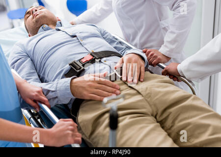 Bewusstlose Patienten, der auf einer Trage in der Klinik Stockfoto