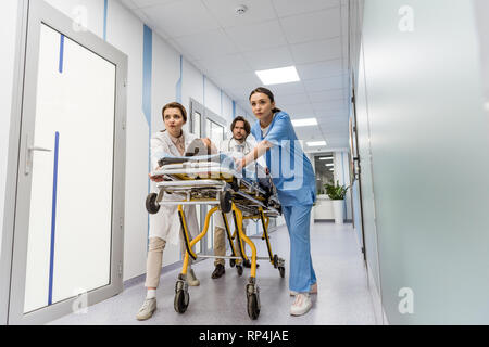 Besorgt, Ärzte und Krankenschwester Transport bewusstlose Patienten auf der Trage Stockfoto