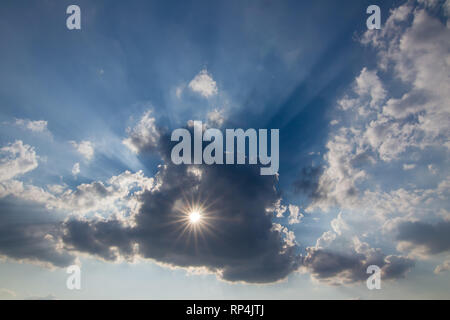 Sonne hinter der Wolke mit einer Bohrung - Sonnenstrahlen. Stockfoto