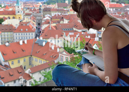 Junge weibliche Künstler sitzen auf Wand über Prag malen Überblick über die Stadt von der Burg Stockfoto