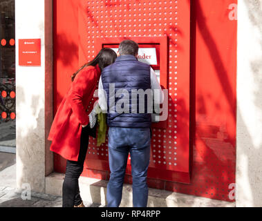 Paar mit einem Geldautomaten zu Santander Bank Filiale in Sevilla, Spanien Stockfoto