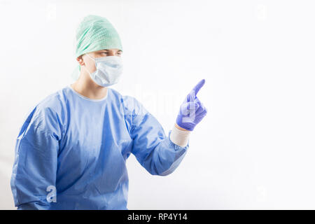 Chirurg Arzt in sterilen Handschuhen Vorbereitung für den Einsatz im Krankenhaus. Er trägt eine chirurgische Gap und blauem Kleid Stockfoto