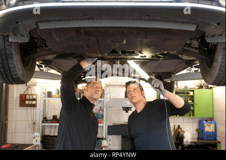 KFZ erklaert Teckniker Meister seinem Lehrling zum KFZ-Mechatroniker. In einer kleinen Werkstatt [(c) Dirk Friedrich A. Stockfoto