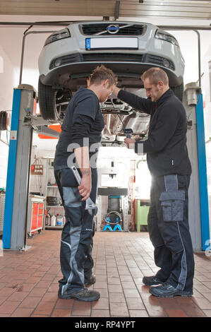 KFZ erklaert Teckniker Meister seinem Lehrling zum KFZ Mechatroniker wie eine Endoskop-Kamera funktioniert. In einer kleinen Werkstatt. [(C) Dirk A. F Stockfoto