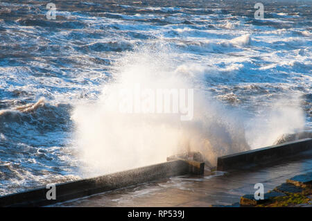 Wellen gegen die Ufermauer in starken Winden auf North shore Klippen im Januar bei Blackpool Lancashire England Großbritannien Stockfoto