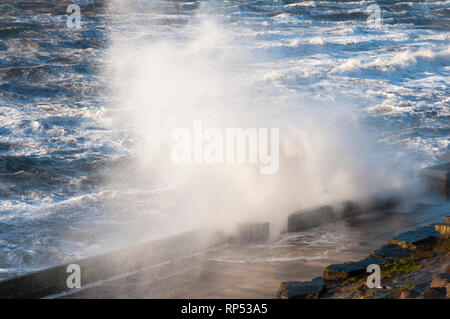 Wellen gegen die Ufermauer in starken Winden auf North shore Klippen im Januar bei Blackpool Lancashire England Großbritannien Stockfoto