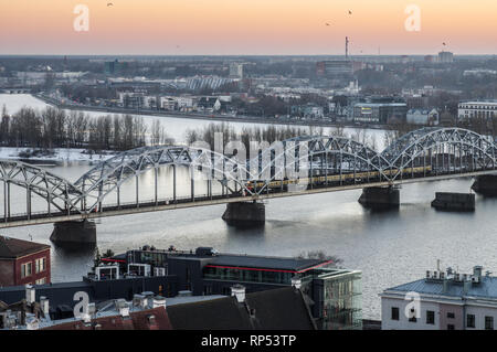 Rosa Himmel über der alten Eisenbahnbrücke in Riga, Lettland Stockfoto