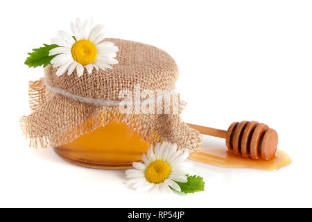 Krug Honig mit Blüten der Kamille auf weißem Hintergrund. Stockfoto