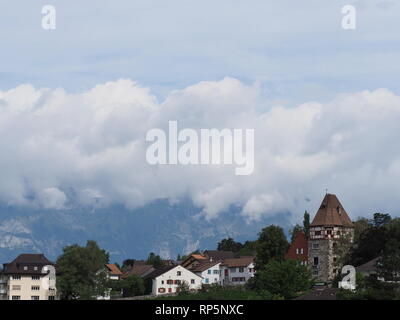 Steiniger Turm und Häuser auf einem Hügel im Stadtbild Landschaften von Wolken über europäische Hauptstadt Vaduz, Liechtenstein mit bewölktem Himmel in 2018 warme Summ Stockfoto