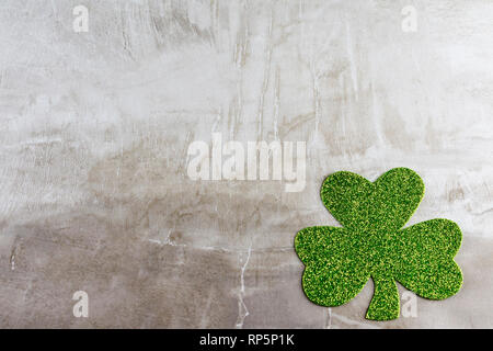 Ein Licht grün glitzernde Shamrock in der unteren rechten Ecke gegen eine tan Steinfliesen. Kopieren Sie Platz. Stockfoto