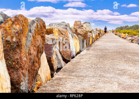 Menschen gehen und laufen auf der breakwall an Harrington, NSW, Australien Stockfoto