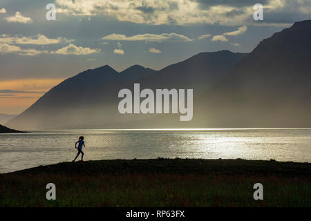 Outdoor runner gegen Dynjandisvogur, Arnarfjordur Fjord, Westfjorde, Island Silhouette. Stockfoto