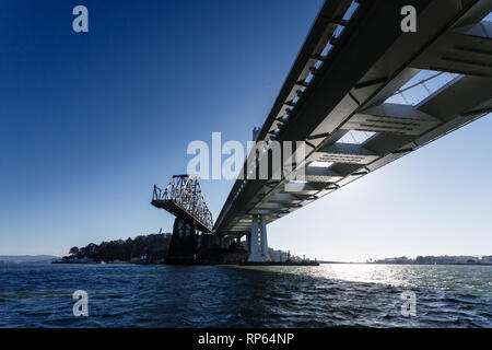 Letzte verbleibende Stück und Turm des alten Bay Bridge in San Francisco von Wasser unter der neuen Brücke aus gesehen Stockfoto