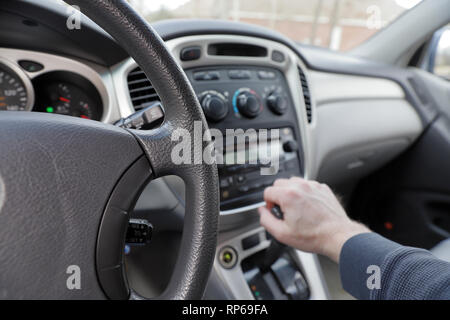 Hand am Fahrzeug Gang, Gang, Radio und Klima steuert - Interieur, front, Dashboard Stockfoto