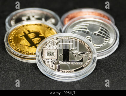 Fünf crypto Währung Münzen mit einem schwarzen Hintergrund und eine lite Münze vor. Stockfoto