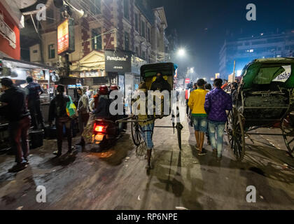 Typische atmosphärischen besetzt in der Nacht laut Zeit Straßenszene in Kolkata mit der lokalen Bevölkerung, Rikschas und Street Food Anbieter. Stockfoto