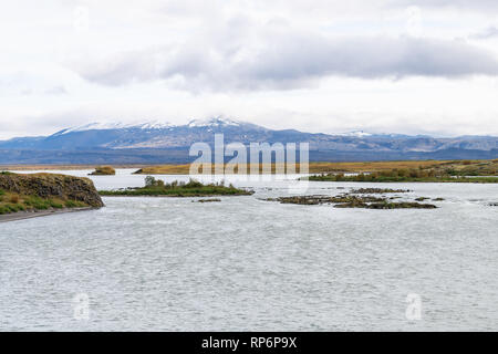 Straße Autobahn 32 in Island auf dem Golden Circle mit Herbst felsige Landschaft Detailansicht an bewölkten Tag- und Flusswasser schneebedeckte Berge Stockfoto