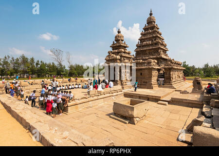 Die Shore Tempel in Mahabalipuram mit Touristen und Einheimischen besucht an einem sonnigen Tag mit blauen Himmel. Stockfoto