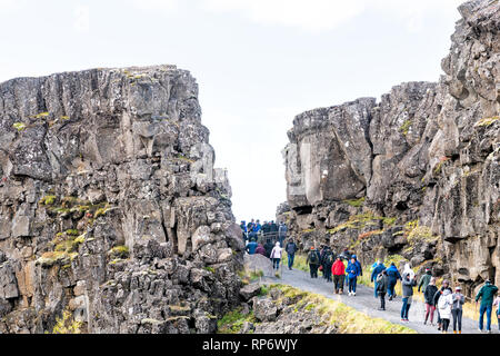 Thingvellir, Island - 20. September 2018: Nationalpark canyon Wasserscheide rocky Platte während Tag Landschaft mit vielen Menschen zu Fuß auf der Spur Stockfoto