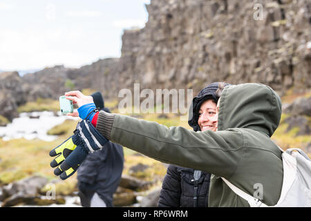 Thingvellir, Island - 20. September 2018: Nationalpark Oxararfoss Wasserfall felsige Landschaft auf Golden Circle mit Wasser Fluss und touristische Paar peo Stockfoto