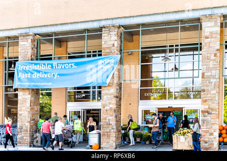 Fairfax, USA - 29. September 2018: Whole Foods Market Zeichen auf äußere Gebäude in der Stadt in Virginia mit Menschen und blau Amazon Prime Lieferung anmelden, indem Stockfoto