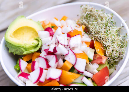 Nahaufnahme des raw vegan Salat Schüssel mit Alfalfa Sprossen, Avocado-, Halb- und gehackten Meerrettich Paprika Mix für Mittag- oder Abendessen gesunde Ernährung Stockfoto