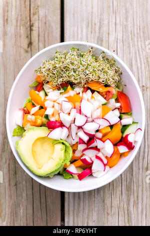 Vertikale flache Oberseite von Raw vegan Salat Schüssel mit Alfalfa Sprossen, Avocado-, Halb- und gehackten Meerrettich Paprika Mix für Mittag- oder Abendessen gesunde Ernährung Stockfoto