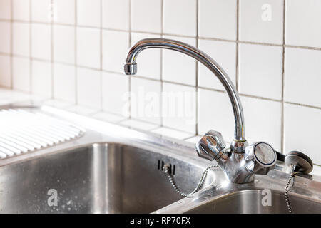 Alte Edelstahl Wasserhahn und Küche Zimmer 2 Waschbecken closeup mit zwei Zifferblättern und Fliesenspiegel in Haus oder Wohnung Stockfoto