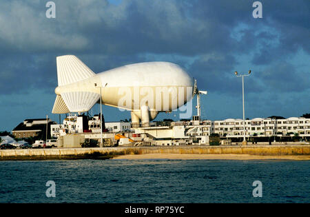 Einen heliumgefüllten Luftschiff, die Antenne Radar Droge zu ermitteln - Schmuggel und anderen illegalen Aktivitäten ist mit einem Schiff eine U.S. Navy Dock in Key West, Florida, USA. Offiziell nennt eine Aerostat, die großen Ballon wird lokal als "Fat Albert" und begann, die in den Bereich zwischen den Florida Keys und Kuba in den 80er Jahren bekannt. Von einem einzigen Kabel angebunden, das unbemannte Blimp geschwommen werden kann bis zu einer Höhe von 15.000 Fuß (4672 m) und Radar Abdeckung über 200 Seemeilen (370 Kilometer). Es ist nun eine von acht aerostats Bereitstellung Überwachung entlang des südlichen Amerikas Grenze. Stockfoto