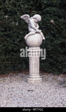 Garten STATUE EINES CHERUBS (geflügelte Engel) Sitzen auf den großen Stein KUGEL MIT EINER KLEINEN Harfe, New South Wales, Australien. Stockfoto