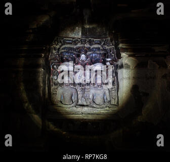 Geschnitzte Statuen des alten hinduistischen Götter beleuchtet mit einer Taschenlampe in einem dunklen Ellora Höhle in der Nähe von Aurangabad, Maharashtra, Indien Stockfoto
