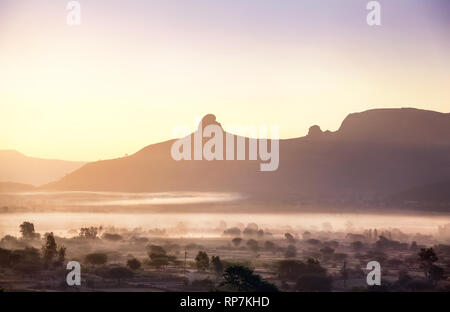 Foggy Mountain Valley bei Sonnenaufgang im Dorf in Nasik, Maharashtra, Indien Stockfoto