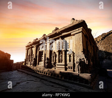 Geschnitzte Statuen des zerstörten Gebäude bei Sonnenuntergang in Ellora Höhle in der Nähe von Aurangabad, Maharashtra, Indien Stockfoto