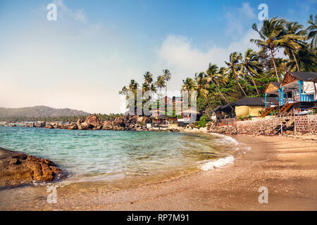 Hütten in der Nähe der Lagune im sonnigen Tag an der traumhaften tropischen Palolem Beach in Goa, Indien Stockfoto