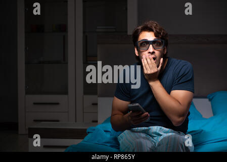 Man Fernsehen am Abend im Bett Stockfoto