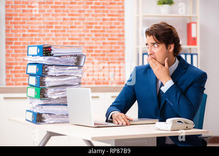 Junge elegante Mann mit zu viel Arbeit unzufrieden Stockfoto