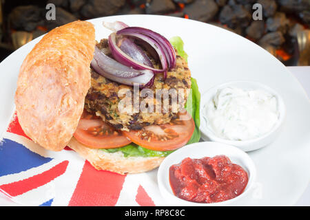 Hausgemachte Quorn Burger in einem sauerteig Brötchen mit Salat, Tomaten, roten Zwiebeln, serviert mit Ketchup und Soja Joghurt Dips. Stockfoto