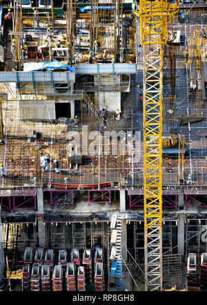 Luftaufnahme der Gebäudekonstruktion mit Turm Kran, Gerüst, Schalung, Ausrüstung und Arbeit Mannschaften platzieren Betonstahl Bars. Stockfoto