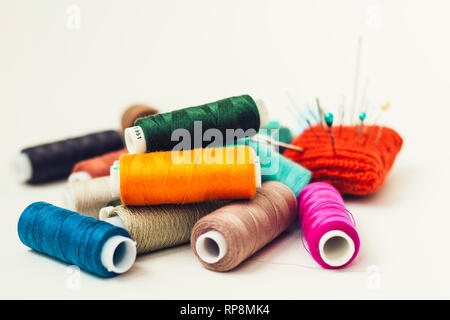 Rote Nadel gestrickt Pad für Nähen und farbige Thema Spulen auf weißem Hintergrund Stockfoto