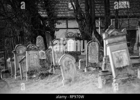 Monochromes Bild von Vandalismus Gräber mit NS-Symbolen in blau Spray - gemalt auf den beschädigten Gräber - Jüdischer Friedhof in Quatzenheim in der Nähe von Straßburg Stockfoto