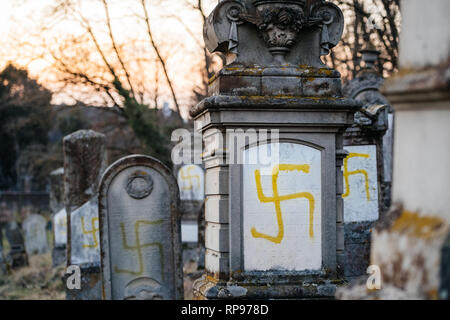 Detail der vandalized Gräber mit NS-Symbolen in gelb Spray - auf den beschädigten Gräber - Jüdischer Friedhof in Quatzenheim in der Nähe von Straßburg lackiert Stockfoto