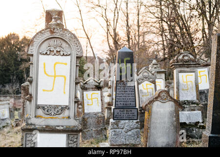 Vandalized Gräber mit Hakenkreuz ns-Symbole in gelb Spray - auf den beschädigten Gräber - Jüdischer Friedhof in Quatzenheim in der Nähe von Straßburg lackiert Stockfoto