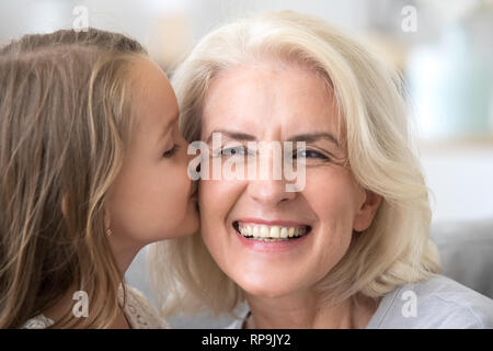 Süße kleine Enkel Großmutter auf die Wange küssen aufgeregt Stockfoto