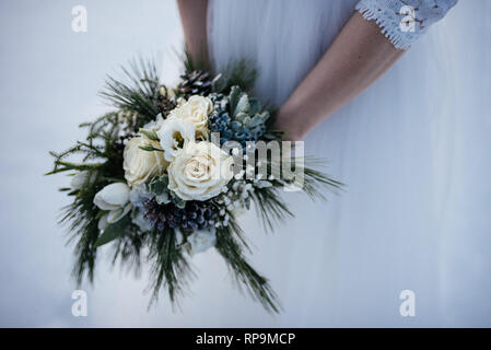 Braut holding Blumenstrauß im weissen Brautkleid Stockfoto