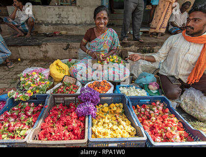 Ein Händler Verkäufer von Blumen lächeln und für die Kamera an der belebten Madurai Blumenmarkt in Indien posieren. Stockfoto