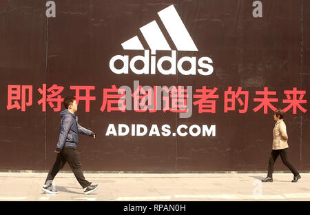 Peking, China. 12 Apr, 2018. Chinesische Spaziergang durch eine massive, bald - - öffnen Adidas Clothing Store in der Innenstadt von Peking am 12. April 2018. China hängt sehr stark von internationalen Einfuhren wie inländische Nachfrage steigt im Jahresvergleich für ausländische Produkte - sowie landwirtschaftlichen Gütern. Quelle: Todd Lee/ZUMAprilESS.com/ZUMA Draht/Alamy leben Nachrichten Stockfoto