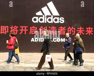 Peking, China. 12 Apr, 2018. Chinesische Spaziergang durch eine massive, bald - - öffnen Adidas Clothing Store in der Innenstadt von Peking am 12. April 2018. China hängt sehr stark von internationalen Einfuhren wie inländische Nachfrage steigt im Jahresvergleich für ausländische Produkte - sowie landwirtschaftlichen Gütern. Quelle: Todd Lee/ZUMAprilESS.com/ZUMA Draht/Alamy leben Nachrichten Stockfoto